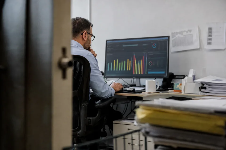 Fraud analyst reviewing a risk score panel on a large monitor